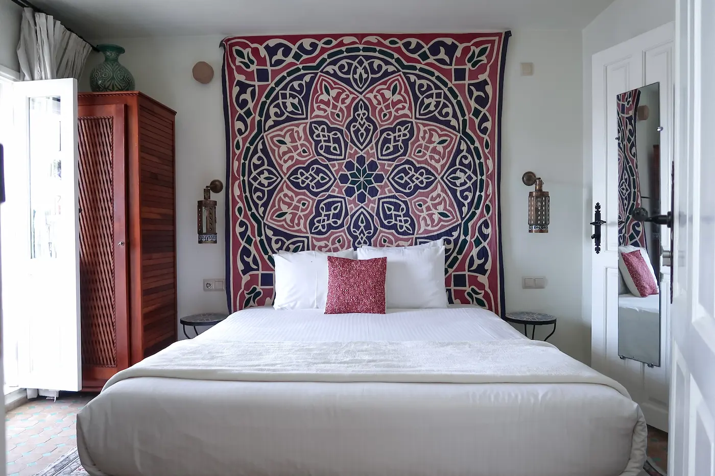 Comfortable bed with ornate Indian bedspread in senior suite at Kasbah Rose Tangier